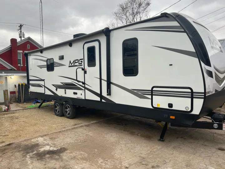 Modern white MPG Ultra-Lite travel trailer, ideal for your next RV rental adventure. Parked on a gravel lot.. Other Other 2021