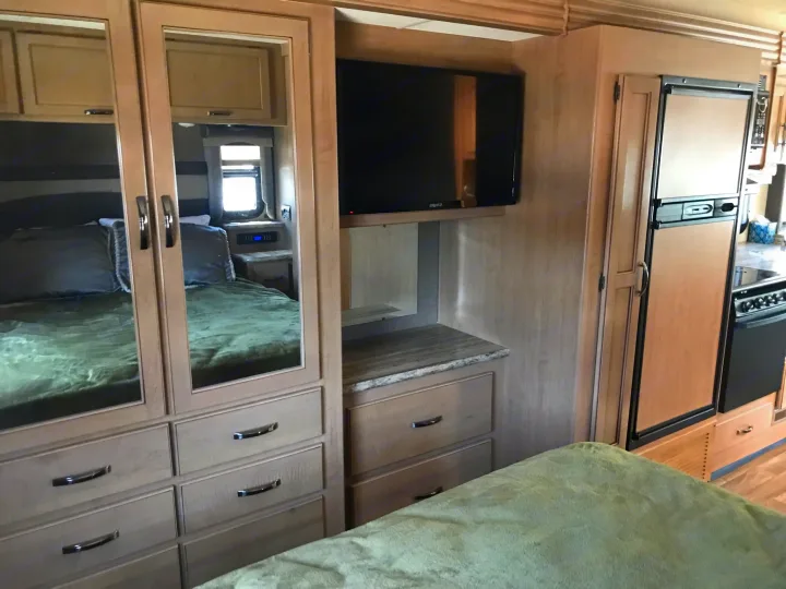 Experience a cozy RV rental interior featuring a bedroom, TV, kitchen, and ample storage for comfortable travels.. Thor Motor Coach A.C.E 2018