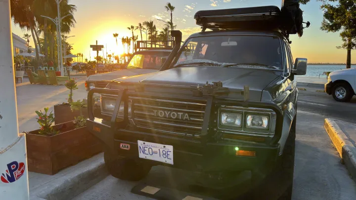 A rugged Toyota Land Cruiser with rooftop tent, a unique RV rental option, enjoys a stunning coastal sunset. BC registered.. Toyota LandCruiser HJ61 VX 1989