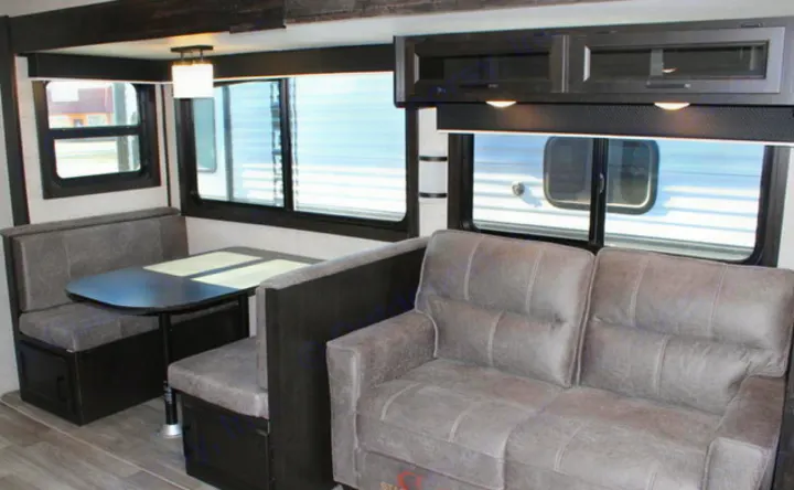 Spacious RV rental interior featuring a modern dining booth and comfortable sofa, designed for travel comfort.. Jayco JayFlight 267BHSW 2022