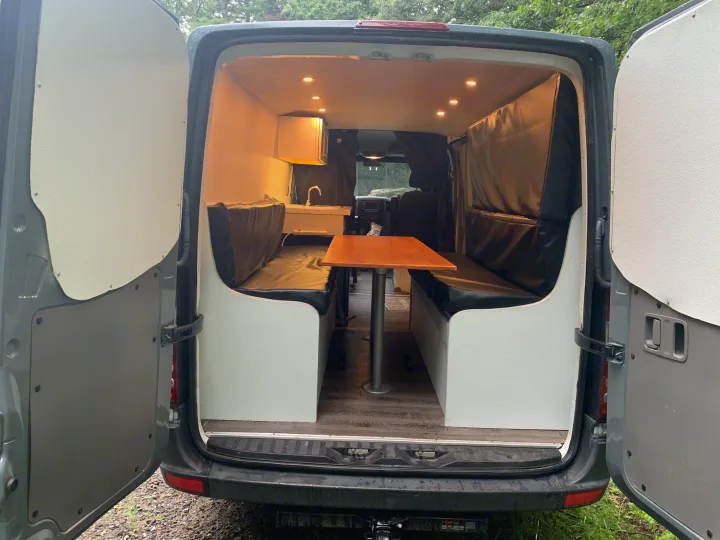 Explore this RV rental's cozy camper interior: dining area, sink, and warm lighting for your mobile adventures.. Mercedes-Benz B class campervan MB 140 2014