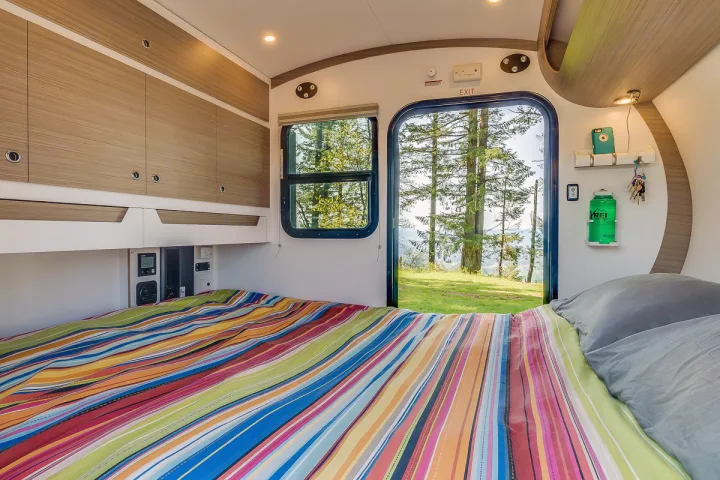 This RV rental offers a compact, cozy bedroom with overhead storage & a view of pine trees. Perfect for adventure!. Bean Trailer Bean Stock 2022