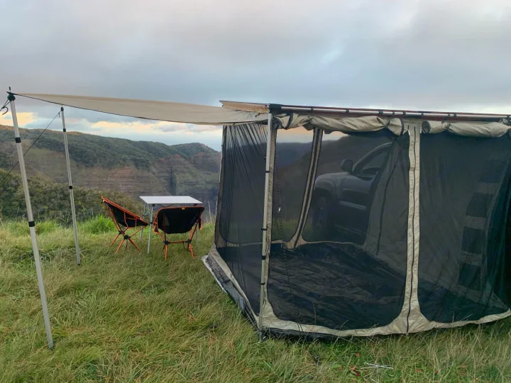 Overland camping setup with a vehicle-attached screen room & awning, chairs, and table, overlooking a scenic valley. Great RV rental alternative!. Toyota 4runner 2003