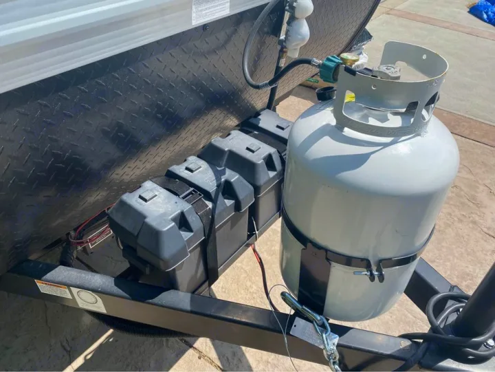 Travel trailer RV rental setup: dual propane tanks, multiple battery boxes, and diamond plate siding.. Jayco Jay Flight SLX Baja Edition 2020