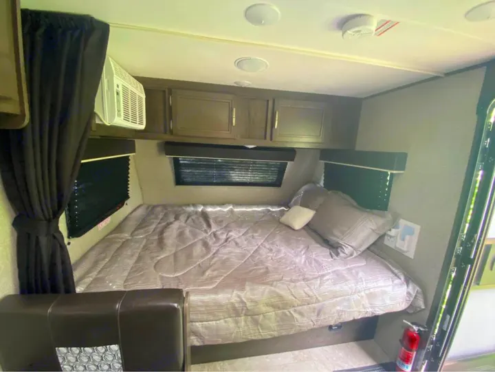 Experience comfortable travel with this **RV rental** bedroom interior, featuring a bed, AC, storage, & safety devices.. Jayco Jay Flight SLX Baja Edition 2020
