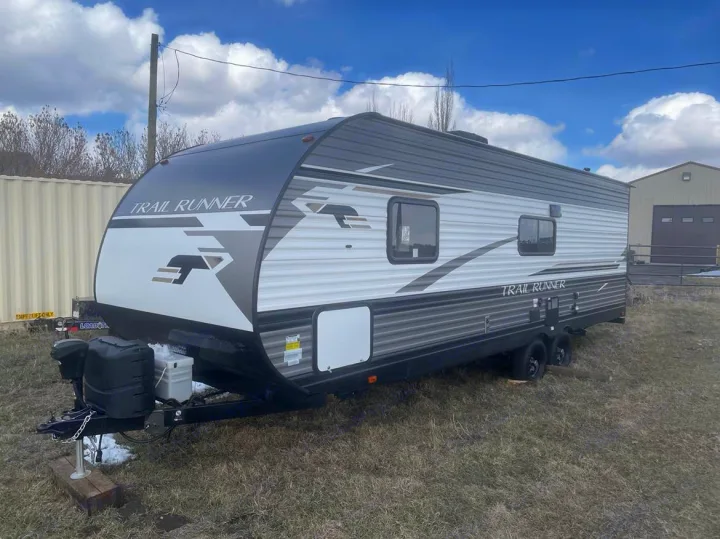 Spacious grey and white Trail Runner travel trailer, perfect for your next RV rental adventure, parked outdoors.. Heartland RVs Trail Runner 2022