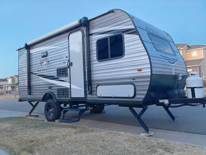 A sleek, grey Jayco Jay Flight SLX Baja travel trailer parked on a street, ideal for an rv rental trip.. Jayco Jay Flight SLX Baja Edition 2020