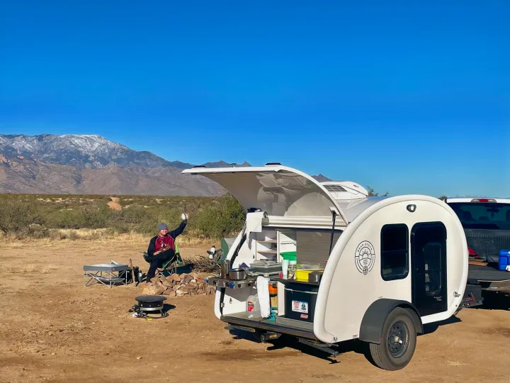 Enjoying the outdoors with an RV rental! This teardrop trailer offers a convenient kitchenette for desert camping near snowy mountains.. Bean Bean Stock 2021