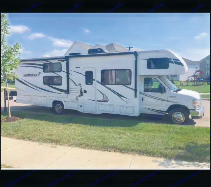 Bright white Sunseeker rv rental, a Class C motorhome, is parked curb-side on a sunny day, ready for travel.. Forest River Sunseeker 2018