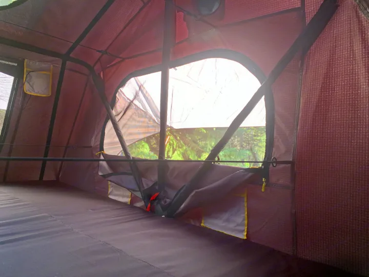 Cozy rooftop tent interior with a plush sleeping pad & scenic tree view. Ideal for an RV rental camping trip.. Smittybilt Overlander XL Gen 2 RTT 2021