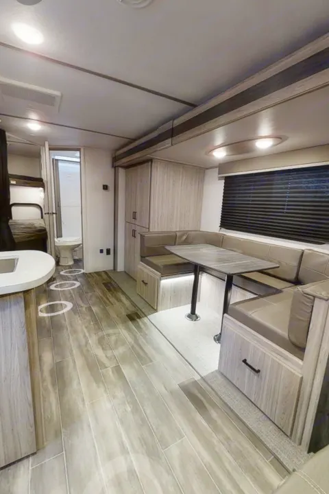 Step inside this RV rental, featuring a practical dinette, kitchen counter, bunk beds, and a rear bathroom.. Keystone RV Keystone Passport 2021
