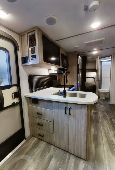 Spacious RV rental interior featuring a modern kitchen, bunk beds, and bathroom, perfect for travel comfort.. Keystone RV Keystone Passport 2021