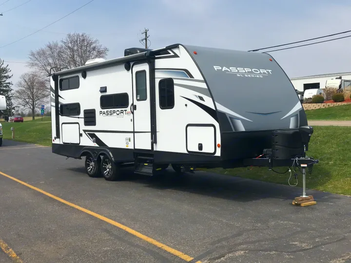 Modern white and grey Keystone Passport travel trailer parked, ready for an RV rental adventure.. Keystone RV Keystone Passport 2021