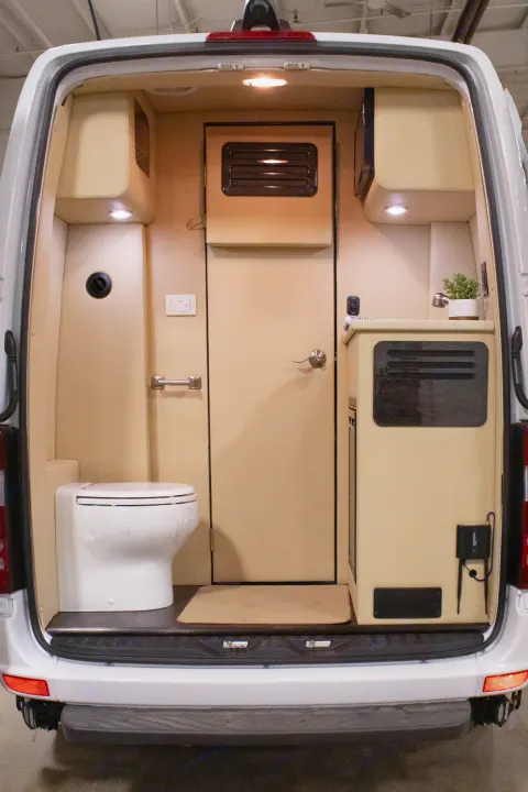 Compact RV rental interior featuring a toilet, kitchenette, and cozy living space inside a camper van.. Ultimate Toys Ultimate Commuter 144 2022