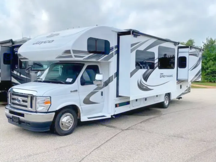 White Jayco Greyhawk Class C motorhome displayed, ideal for rv rental. Features extended slide-outs for extra space.. Jayco Greyhawk 2021