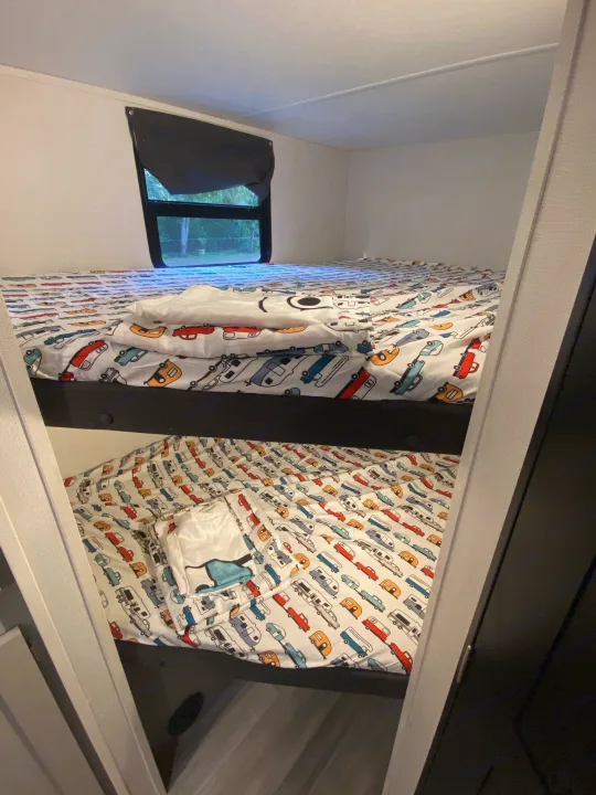 RV rental bunk beds, perfect for kids. Two stacked beds with colorful car/truck bedding visible in this RV interior.. Other Tracer 2022