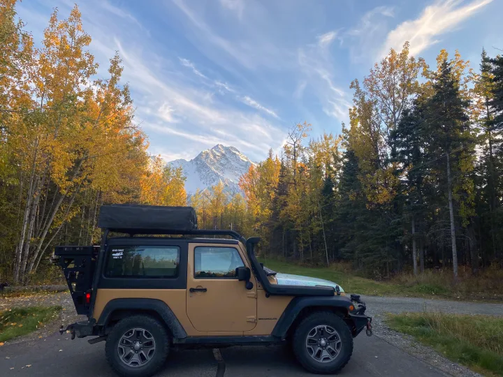 A modified Jeep explores fall colors, snowy mountains. An RV rental could offer similar epic nature adventures.. Jeep Rubicon 2014