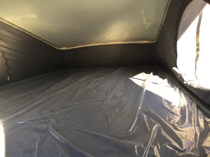 RV rental: Inside a pop-top camper featuring a light ceiling, dark fabric walls, and a crinkled plastic-covered floor.. Winnebago Solis 2022