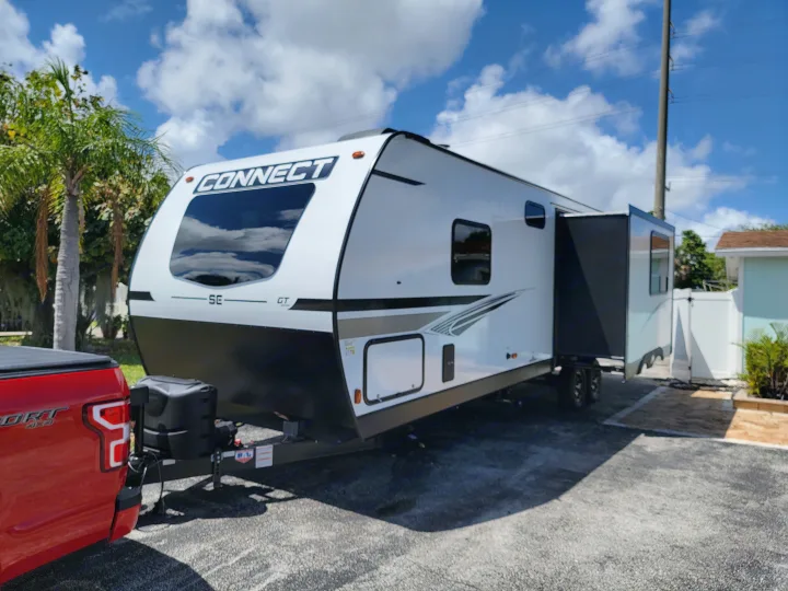 White Connect travel trailer for rv rental, hitched to a red pickup. Extended slide-out, ready for your next adventure!. Otherl Other 2022