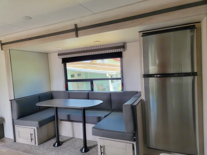 This inviting RV rental features a clean, modern dinette with U-shaped booth seating and a stainless steel refrigerator.. Otherl Other 2022