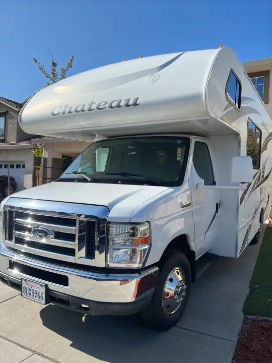 A bright white Chateau Class C motorhome, ready for an RV rental adventure, parked on a sunny driveway.. Thor Chateau 2012