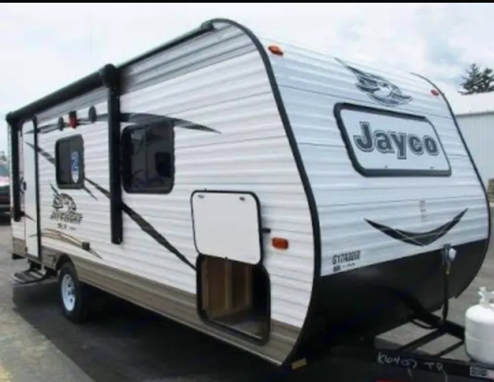 White & brown Jayco travel trailer RV with awning, windows, and open storage. Consider this recreational vehicle for an rv rental.. Jayco Jay Flight 2016