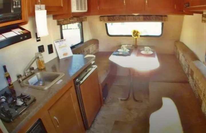 This RV rental interior features a compact kitchen with a sink, stove, and a cozy dinette area, perfect for travel.. Jayco Jay Flight 2016