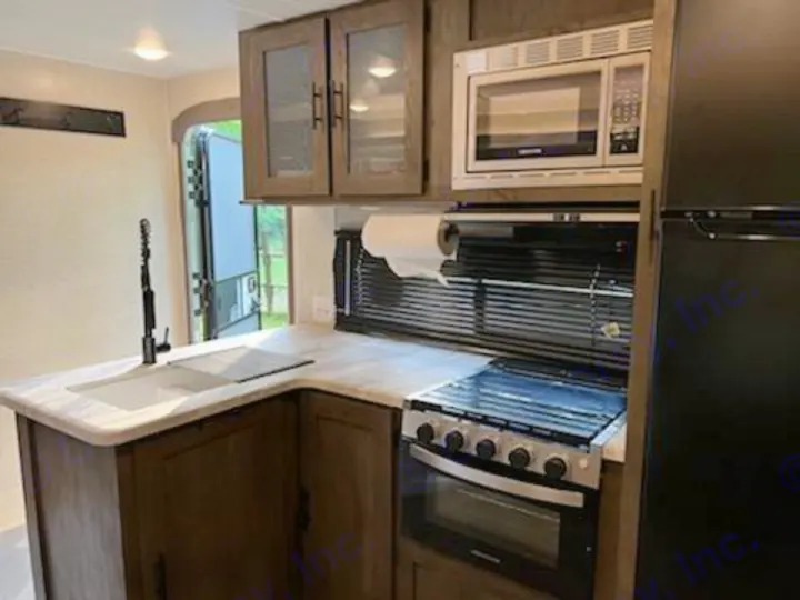 Explore this clean RV rental kitchen with sink, stove, microwave, and fridge. Perfect for your next adventure!. Forest River Salem 2021