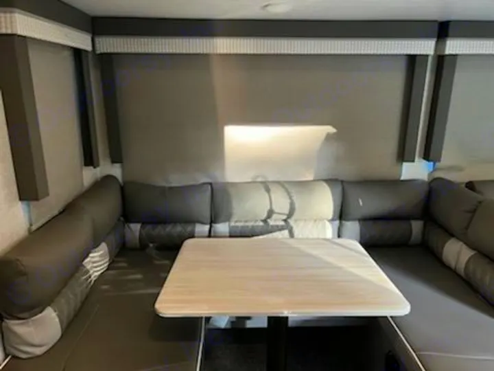 Spacious RV rental interior featuring a comfortable U-shaped grey dinette and a light-colored table.. Forest River Salem 2021