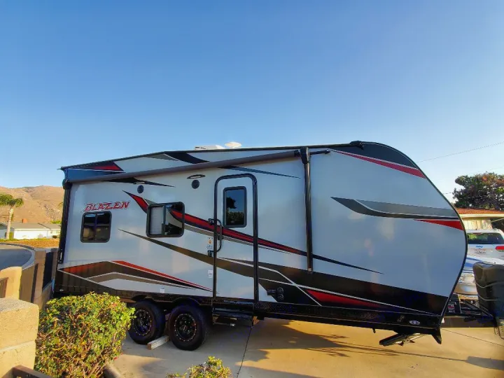 Grey Blazen toy hauler RV rental with red/black graphics, parked and ready for adventure.. Pacific Coachworks Blaze'N 2022