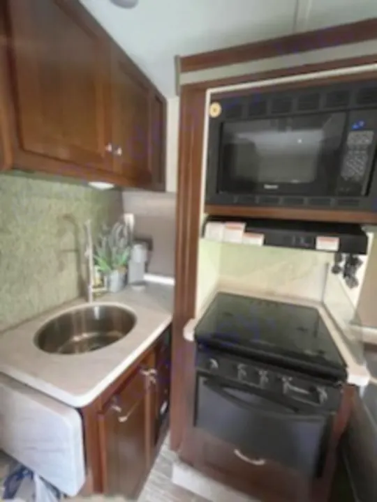 This RV rental's efficient kitchen boasts a sink, microwave, oven, and ample cabinetry for convenient travel cooking.. Forest River Sunseeker 2018