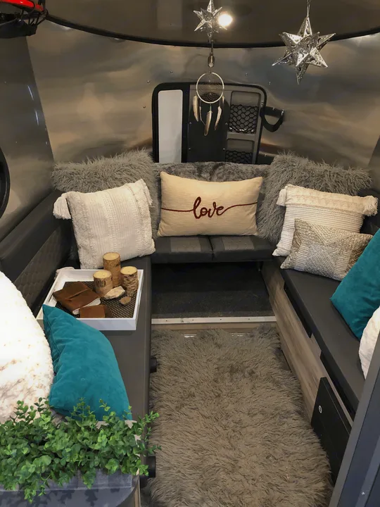 The bed converts to the "living room" and the table gets set up in the middle for dining. 4 people can easily fit and we've had 6!. Airstream Basecamp X 2021