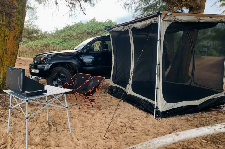 Overland SUV camping setup with attached tent, table, and chairs on sandy ground, ready for your **RV rental** adventure.. Toyota 4runner 2003