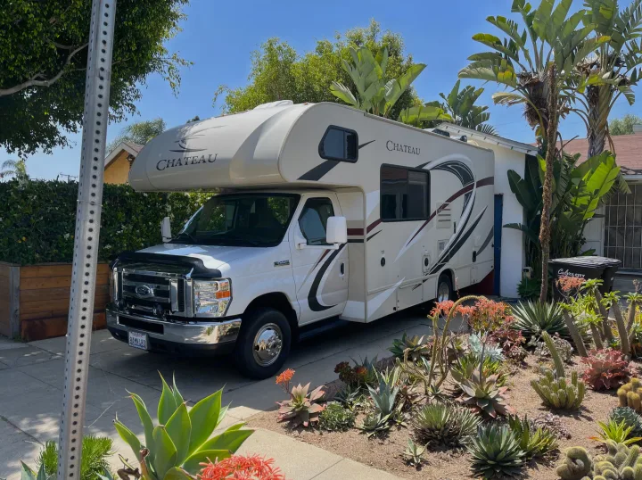 White Chateau RV rental parked in a sunny driveway with a lush succulent garden foreground. Perfect for your next adventure.. Thor Chateau 2017