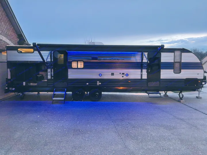 Experience an RV rental at night! This travel trailer features vibrant blue lights & an extended awning, ready for adventure.. Forest River Cherokee Grey Wolf 2022