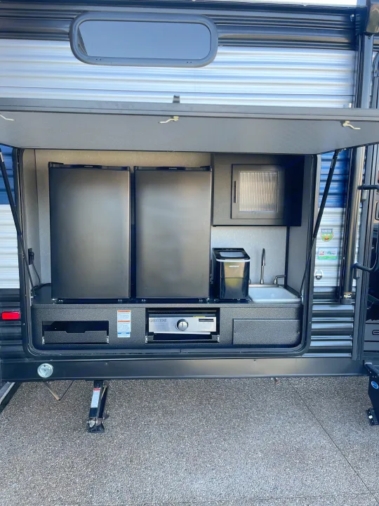 RV rental outdoor kitchen with dual fridges, ice maker, sink, and grill. Perfect for camp cooking and entertaining.. Forest River Cherokee Grey Wolf 2022