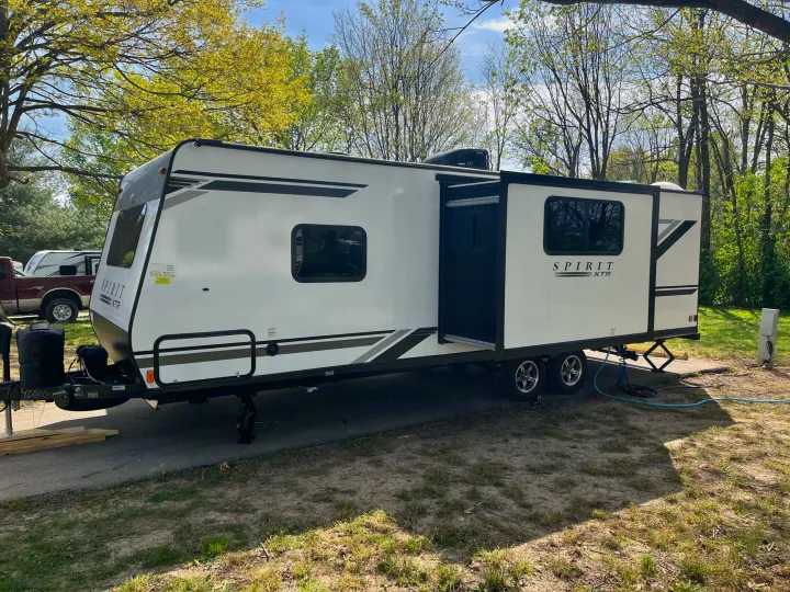 White Spirit XTR travel trailer RV rental at a sunny campsite, extended for comfort. Ready for adventure!. Coachmen 2549 BHX 2021
