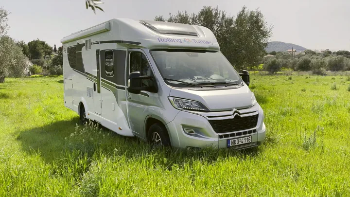 Modern grey RV rental, a Rolling Turtles camper van, parked in a lush green field. Perfect for road trips and adventure.. Carado T459 2022