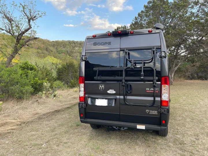 Rear view of a gray Thor Scope camper van with bike rack & satellite, ideal for an rv rental in nature.. Thor Scope 18M 2022