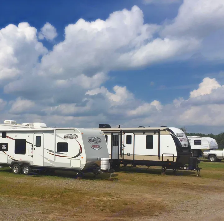Multiple RVs and travel trailers, including Jay Flight and Wildcat models, parked in an open lot. Consider rv rental for adventure!. Jayco Coyote 2014