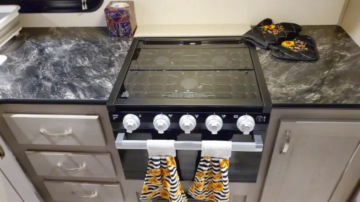 Enjoy home comforts in your RV rental! This compact kitchen features a stove, oven, and ample countertop, ready for meals on the road.. Forest River PRIME TIME 2022