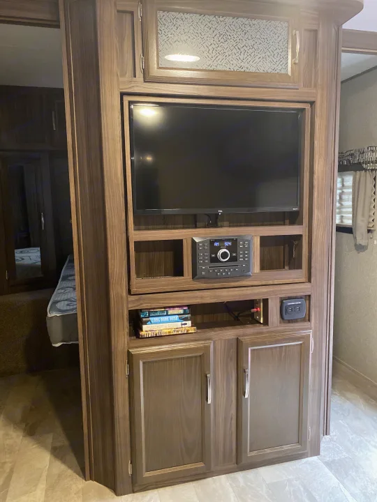 Compact RV rental entertainment hub: TV, stereo, charging center, and shelves for books and essentials.. Coachmen Other 2019