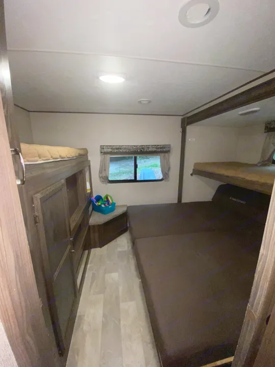 Experience comfort in this rv rental. Interior view of a bunk room with upper and lower beds, storage, and a window.. Coachmen Other 2019