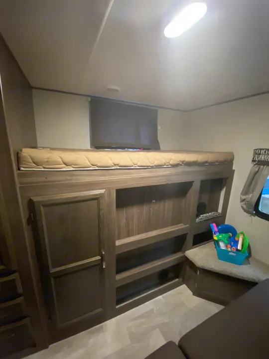 Inside an RV rental: Cozy bunk bed with built-in storage, plus seating & toys in the living area.. Coachmen Other 2019
