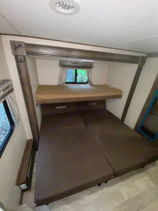 Inside this RV rental: Bunk beds offer sleeping space, with a lower convertible dinette and window view.. Coachmen Other 2019