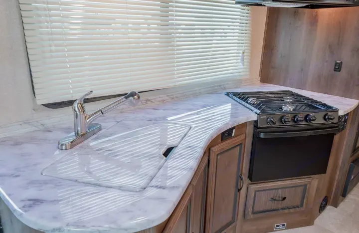 RV rental with a modern kitchen: spacious counters, pull-out faucet, and a gas stove/oven, ready for adventure.. Coachmen Freelander 28BH 2018