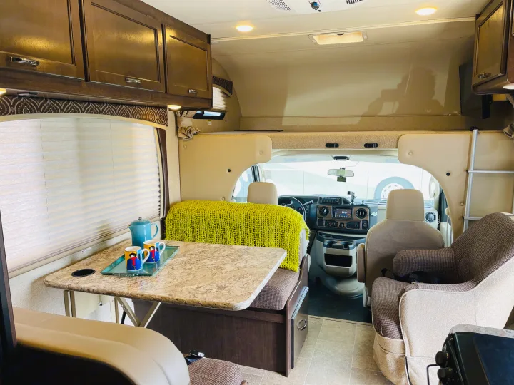 Explore this inviting RV rental interior, featuring a dinette, lounge, and cab. Perfect for comfortable road trip adventures.. Thor Chateau 2017