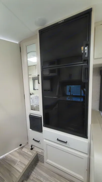 RV rental interior showcases a large Dometic refrigerator, mirrored pantry, and compact kitchen with modern design.. Ford Freedom Elite 2022