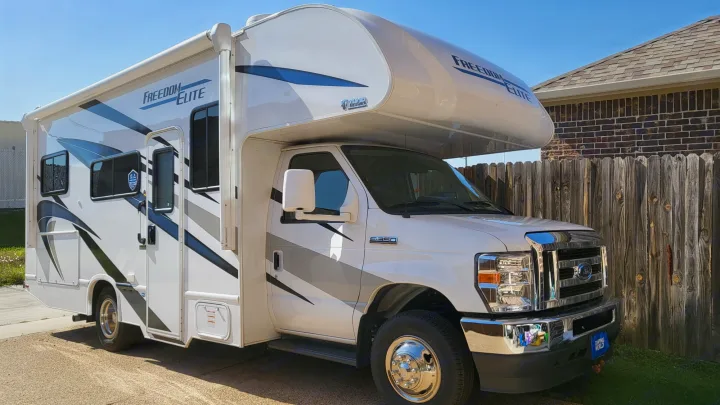 Clean white Freedom Elite Class C motorhome (RV) rental parked outdoors on a sunny day.. Ford Freedom Elite 2022