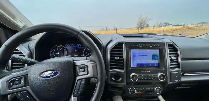Ford vehicle interior, dashboard, and rural landscape view. Ready for an RV rental road trip!. Ford Ford Expedition 2021